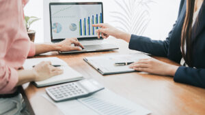 An accountant and a client reviewing accounting information on a laptop in El Paso.