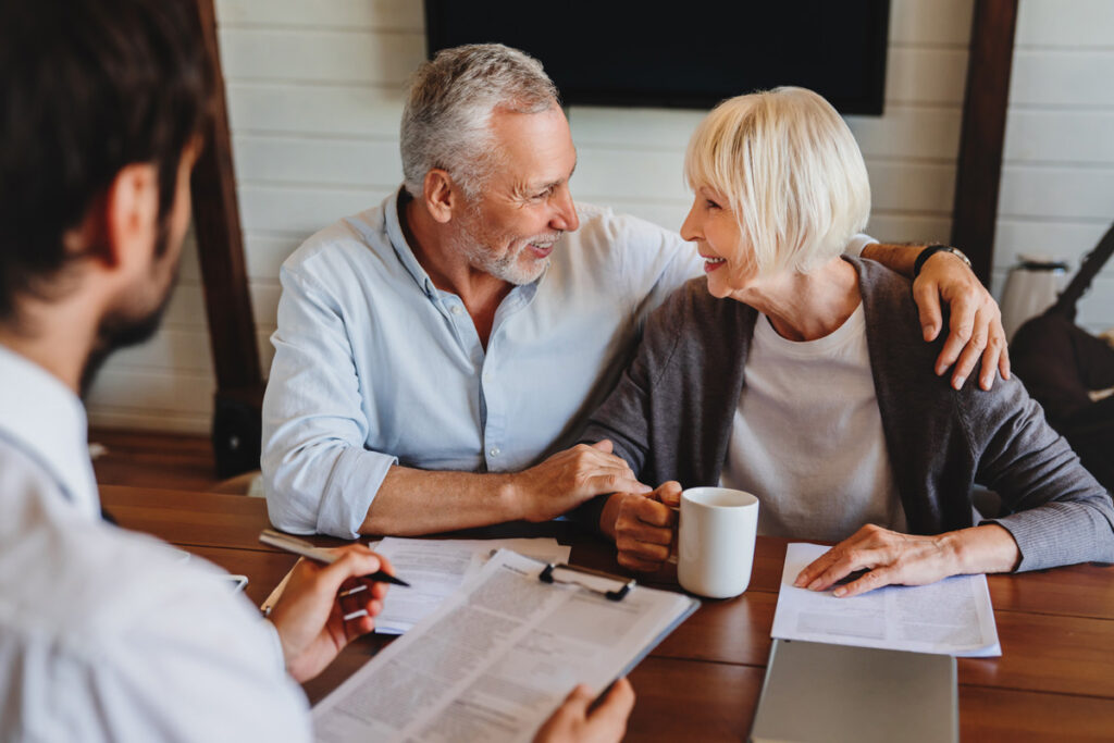 A smiling couple reviewing estate taxes with an accountant in El Paso.