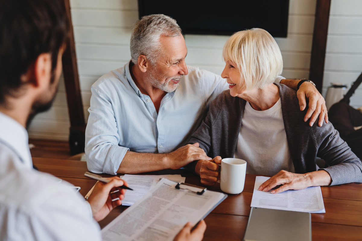 A smiling couple reviewing estate taxes with an accountant in El Paso.