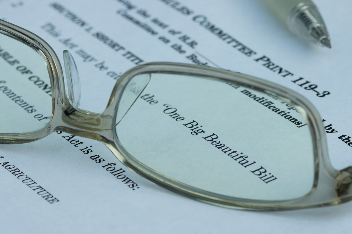 A pair of glasses on top of a piece of paper that reads “One Big Beautiful Bill”.